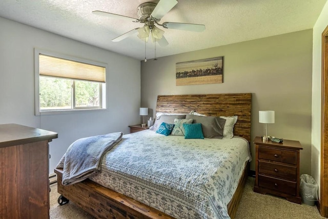 bedroom with light carpet, a textured ceiling, a baseboard radiator, and ceiling fan