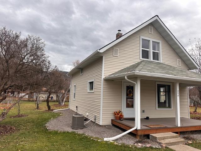 back of property featuring a lawn, covered porch, and central AC