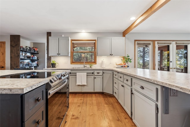 kitchen featuring french doors, sink, beamed ceiling, stainless steel electric range, and light wood-type flooring