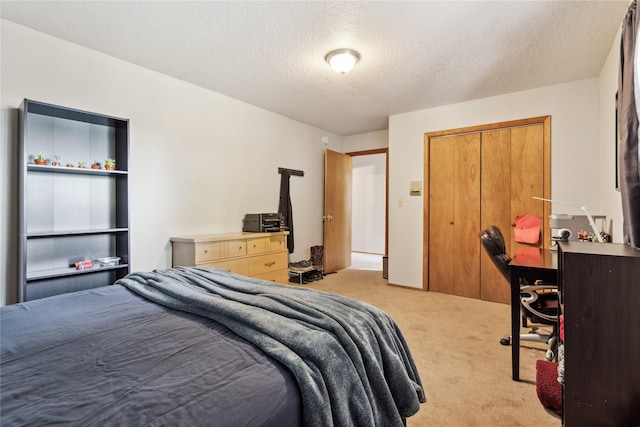 carpeted bedroom with a textured ceiling and a closet