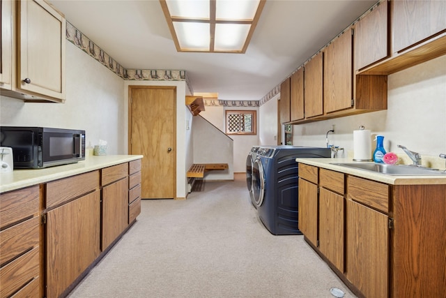 laundry area with separate washer and dryer, light carpet, sink, and cabinets