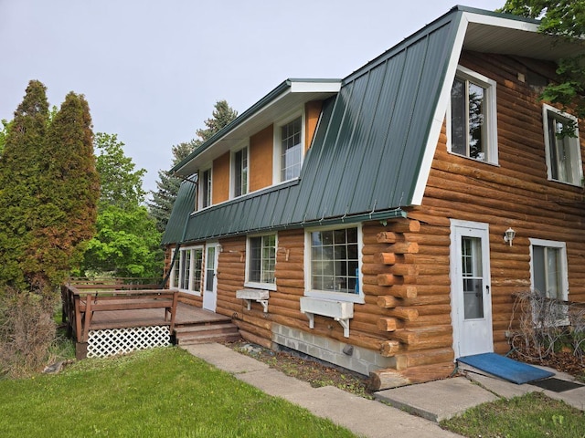 view of property exterior with a lawn and a wooden deck