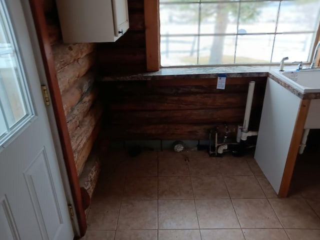 interior space featuring white cabinets, sink, and light tile patterned floors