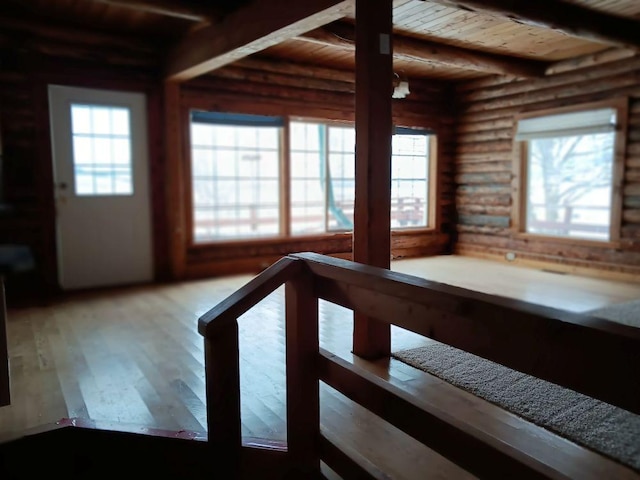 hallway featuring beamed ceiling, log walls, wooden ceiling, and wood-type flooring