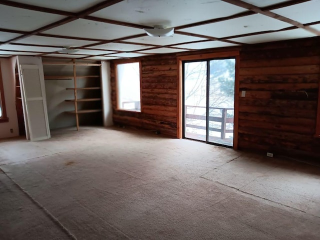 unfurnished living room featuring wood walls