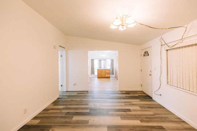 interior space featuring a chandelier, dark hardwood / wood-style floors, and vaulted ceiling