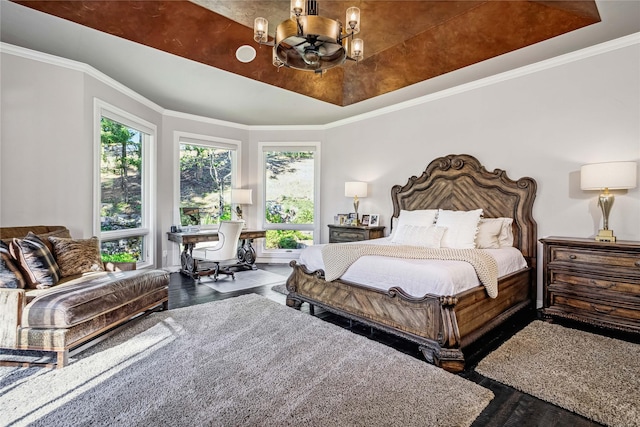 bedroom featuring crown molding, wood finished floors, a raised ceiling, and a chandelier