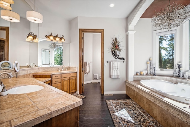 bathroom with vanity, wood finished floors, a garden tub, and a healthy amount of sunlight