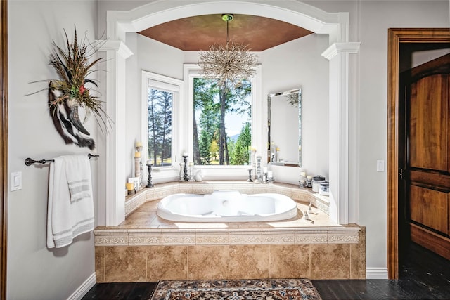 full bath featuring a garden tub and decorative columns