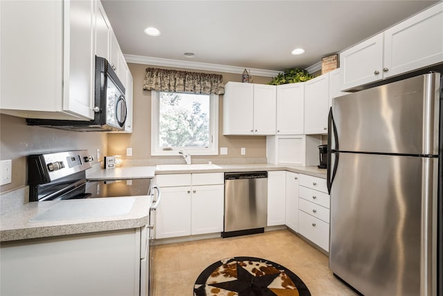 kitchen featuring white cabinetry, light countertops, appliances with stainless steel finishes, and a sink