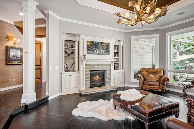 living room with a glass covered fireplace, baseboards, dark wood-type flooring, and ornate columns