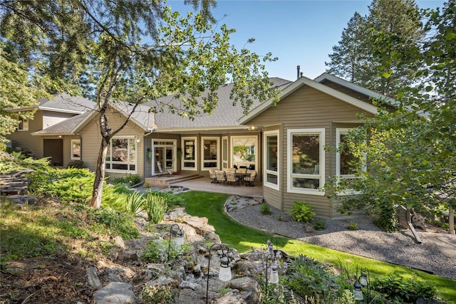 back of house featuring a shingled roof and a patio area