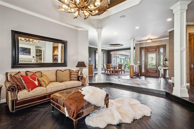 living area with ornamental molding, wood finished floors, an inviting chandelier, baseboards, and ornate columns