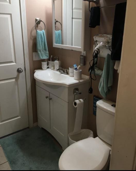 bathroom featuring toilet, vanity, and tile patterned flooring