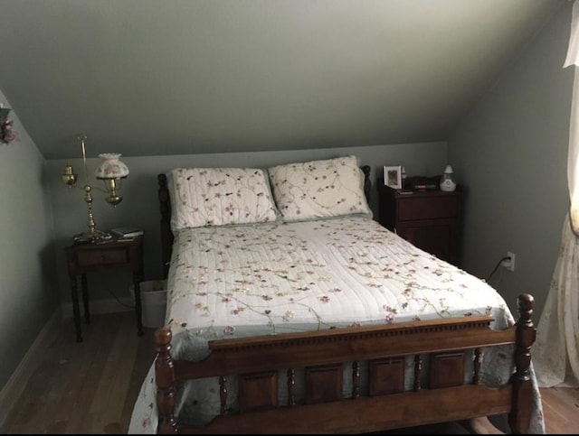 bedroom with lofted ceiling and hardwood / wood-style flooring