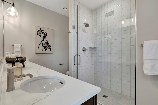 bathroom featuring toilet, walk in shower, and vanity