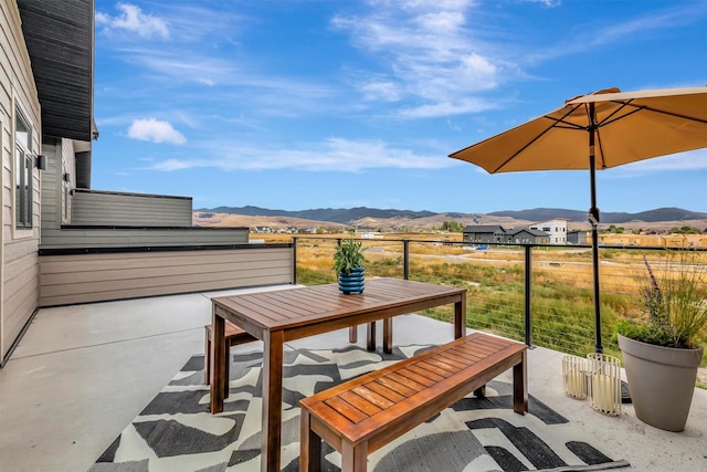 view of patio featuring a mountain view and a balcony