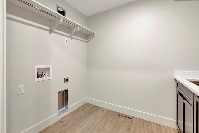 laundry room with cabinets, washer hookup, light hardwood / wood-style flooring, and electric dryer hookup