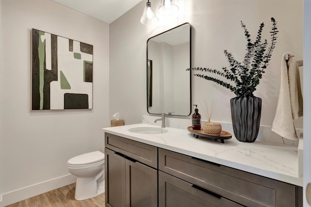 bathroom featuring toilet, hardwood / wood-style flooring, and vanity