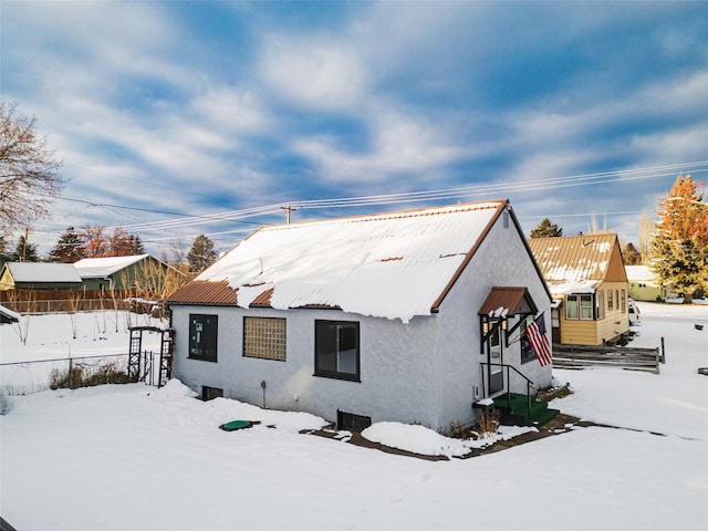 view of snow covered back of property