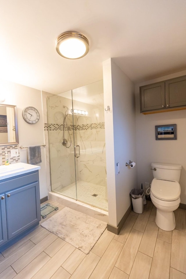 bathroom featuring toilet, an enclosed shower, tasteful backsplash, and vanity