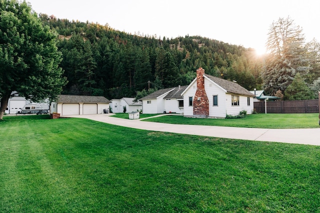 view of front of property featuring an outbuilding, a front lawn, and a garage