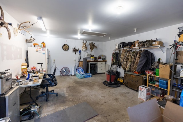 garage featuring a workshop area and white fridge