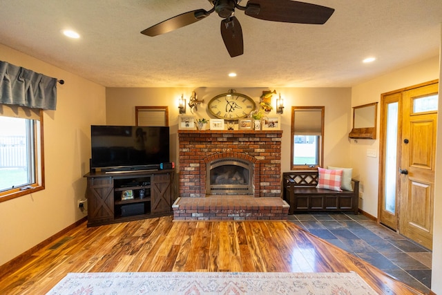 unfurnished living room featuring a textured ceiling, dark hardwood / wood-style flooring, a wealth of natural light, and a fireplace