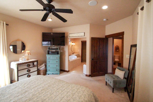 bedroom featuring light colored carpet, ceiling fan, and connected bathroom