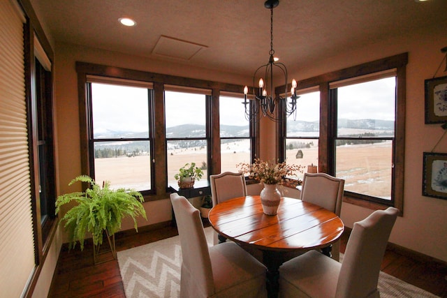 dining area with hardwood / wood-style flooring, a chandelier, and a water and mountain view