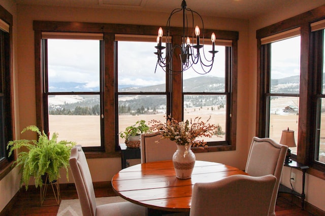 dining area with hardwood / wood-style floors, a water and mountain view, and a chandelier