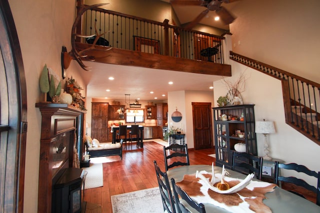 dining room with a high ceiling, light wood-type flooring, and ceiling fan