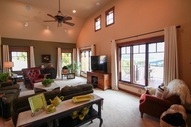 carpeted living room with ceiling fan and a high ceiling