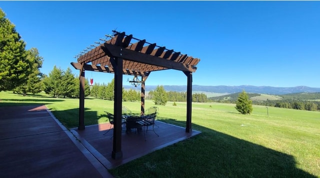 view of home's community with a patio, a lawn, a mountain view, and a pergola