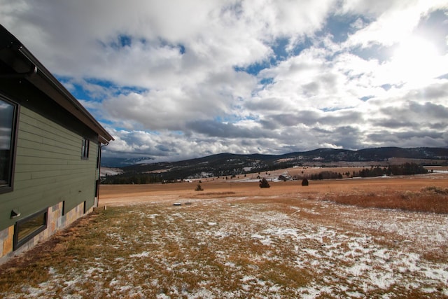 snowy yard featuring a rural view and a mountain view