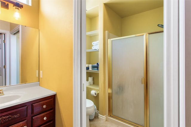 bathroom featuring toilet, an enclosed shower, vanity, and tile patterned floors