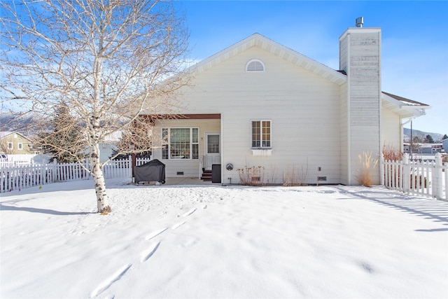 view of snow covered back of property