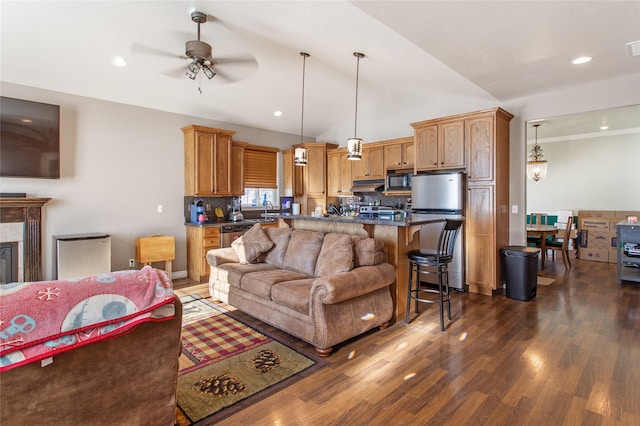 living room with lofted ceiling, dark wood-type flooring, and ceiling fan