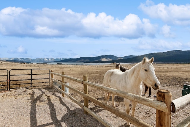 view of horse barn featuring a rural view and a mountain view