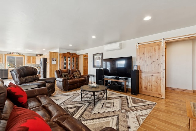 living room featuring a wall unit AC, hardwood / wood-style floors, and a barn door