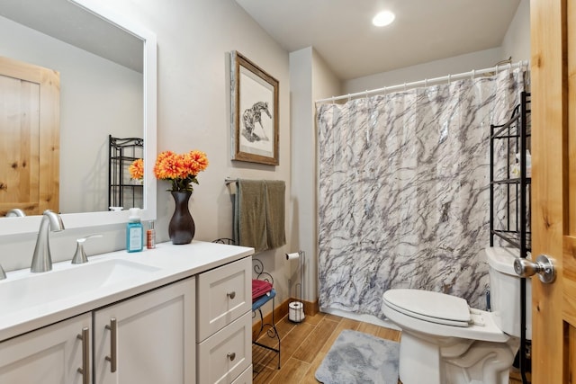 bathroom featuring toilet, a shower with shower curtain, and vanity