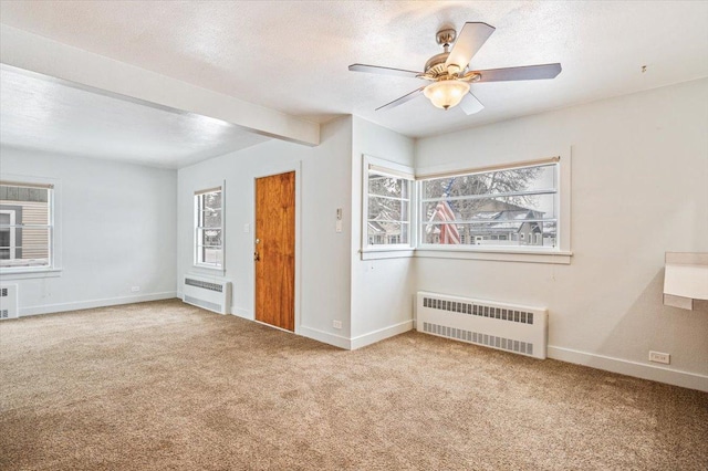 carpeted empty room with a textured ceiling, ceiling fan, and radiator