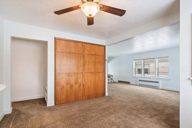 unfurnished bedroom featuring a closet, radiator, carpet floors, ceiling fan, and a baseboard radiator