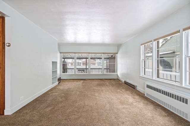 carpeted empty room with a baseboard radiator and radiator