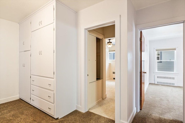 corridor with light colored carpet and radiator