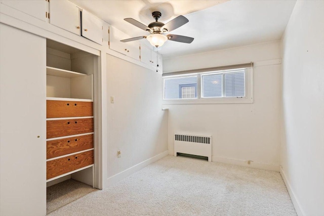 unfurnished bedroom featuring ceiling fan, light carpet, and radiator