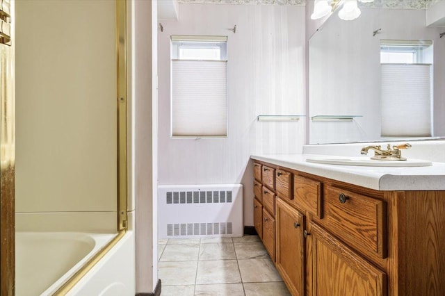 bathroom featuring radiator, vanity, tile patterned floors, and  shower combination