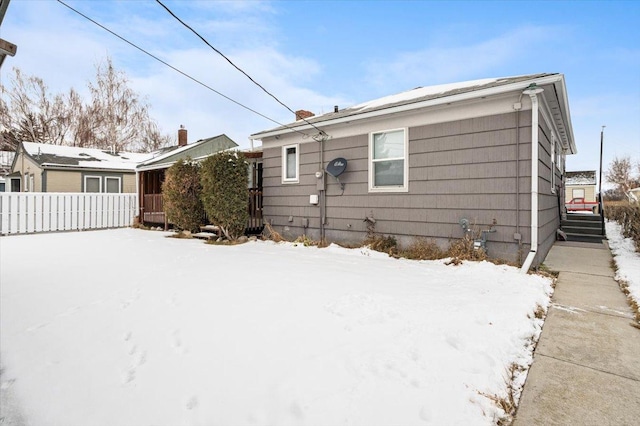 view of snow covered rear of property