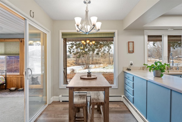 dining room featuring dark wood-type flooring, a baseboard radiator, and a chandelier