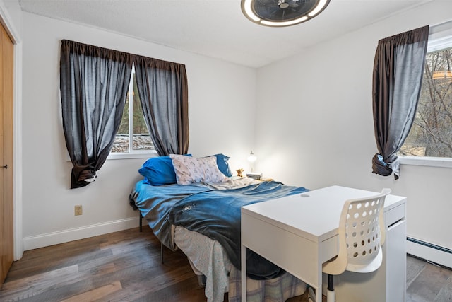 bedroom featuring baseboard heating and dark wood-type flooring